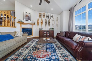 Una sala de estar con chimenea, un sofá, una mesita de centro y una alfombra.