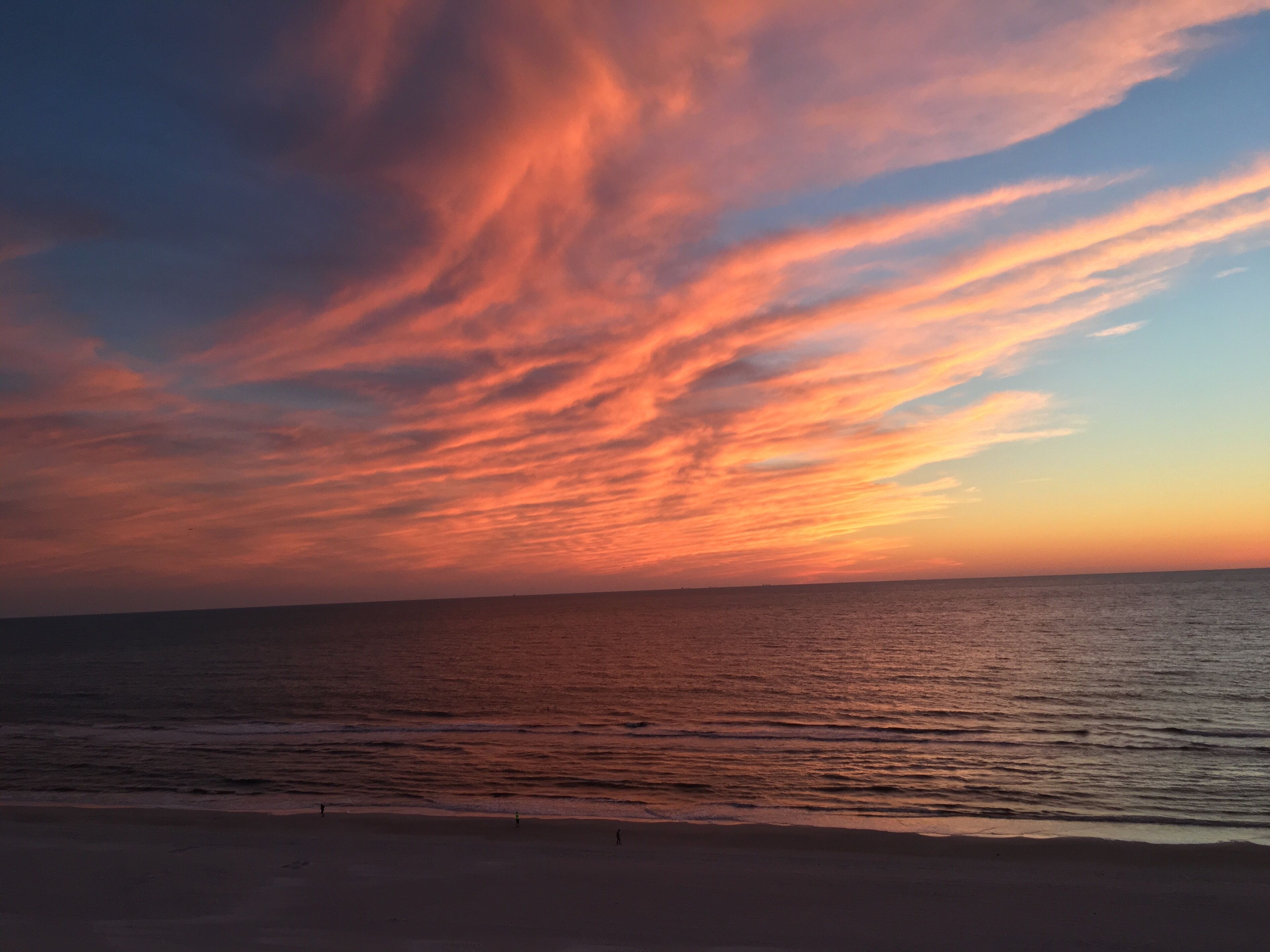 Una playa con un atardecer y el océano.