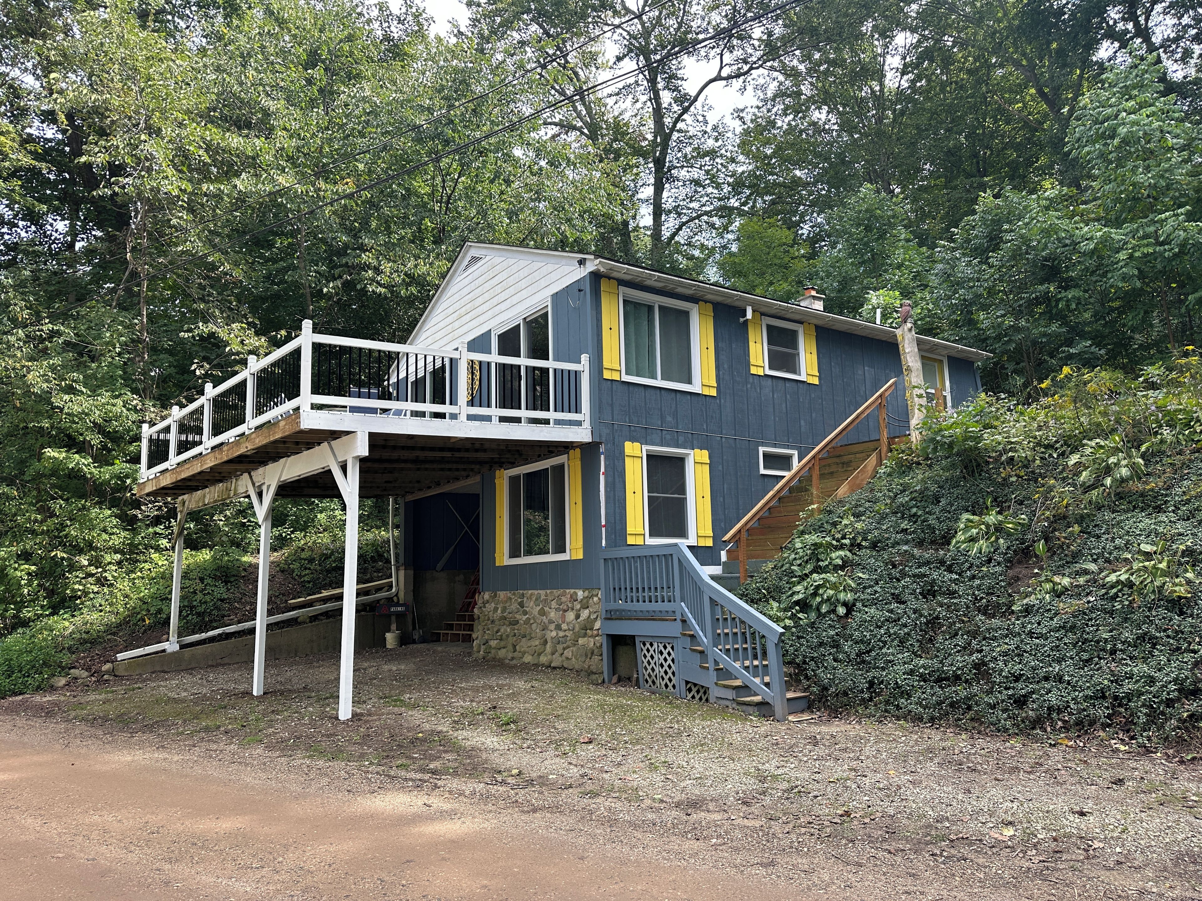 A two-story house with a balcony and a staircase leading to the upper level.