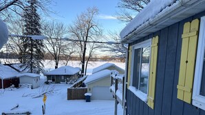 A snow-covered residential area with houses, a wooden fence, and a clear sky. - Country cottage, Baseline Lake . Come fish, kayak or enjoy a camp fire.  (Gobles)