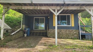 A two-story house with a covered porch and a stone wall. - Country cottage, Baseline Lake . Come fish, kayak or enjoy a camp fire.  (Gobles)