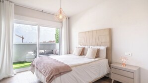 A bedroom with a large bed, a nightstand, and a view of a balcony with a construction crane. - Stunning Apartment in Estepona, Spain Private Pool (Estepona)