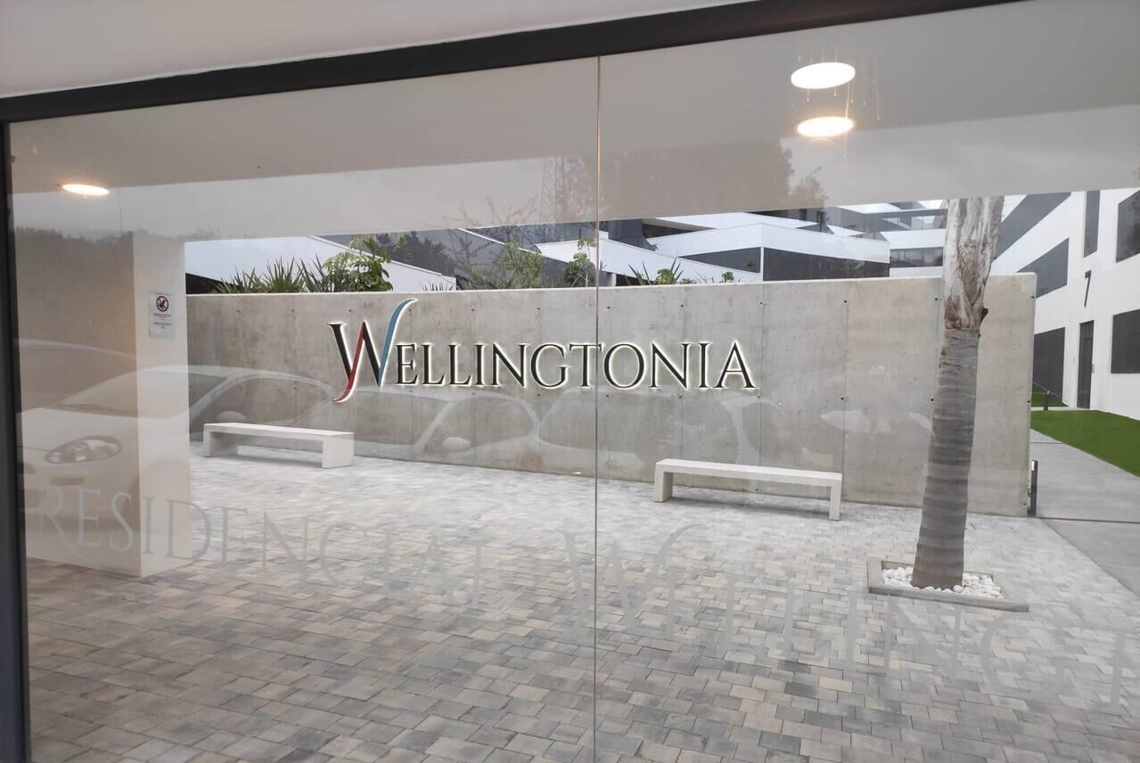 En modern byggnadsfasad med namnet ”Wellingtonia” tydligt synligt.