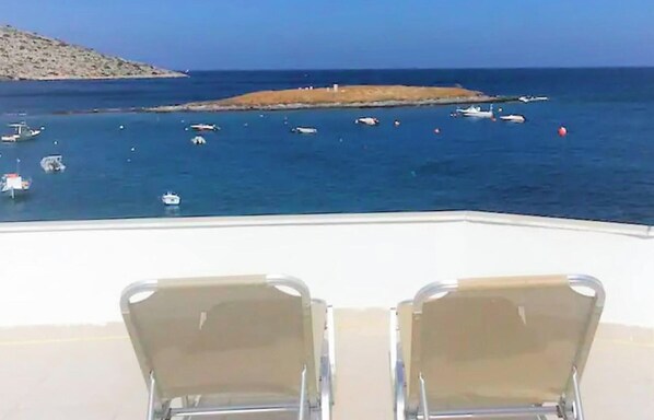 A view of a coastal area with boats on the water and two empty chairs in the foreground. - Remarkable 3double-Bed House in Daskalio (Daskalio)