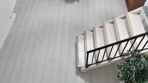 A spacious living area with a dining table, sofa, and staircase. - Apartment (Riez)