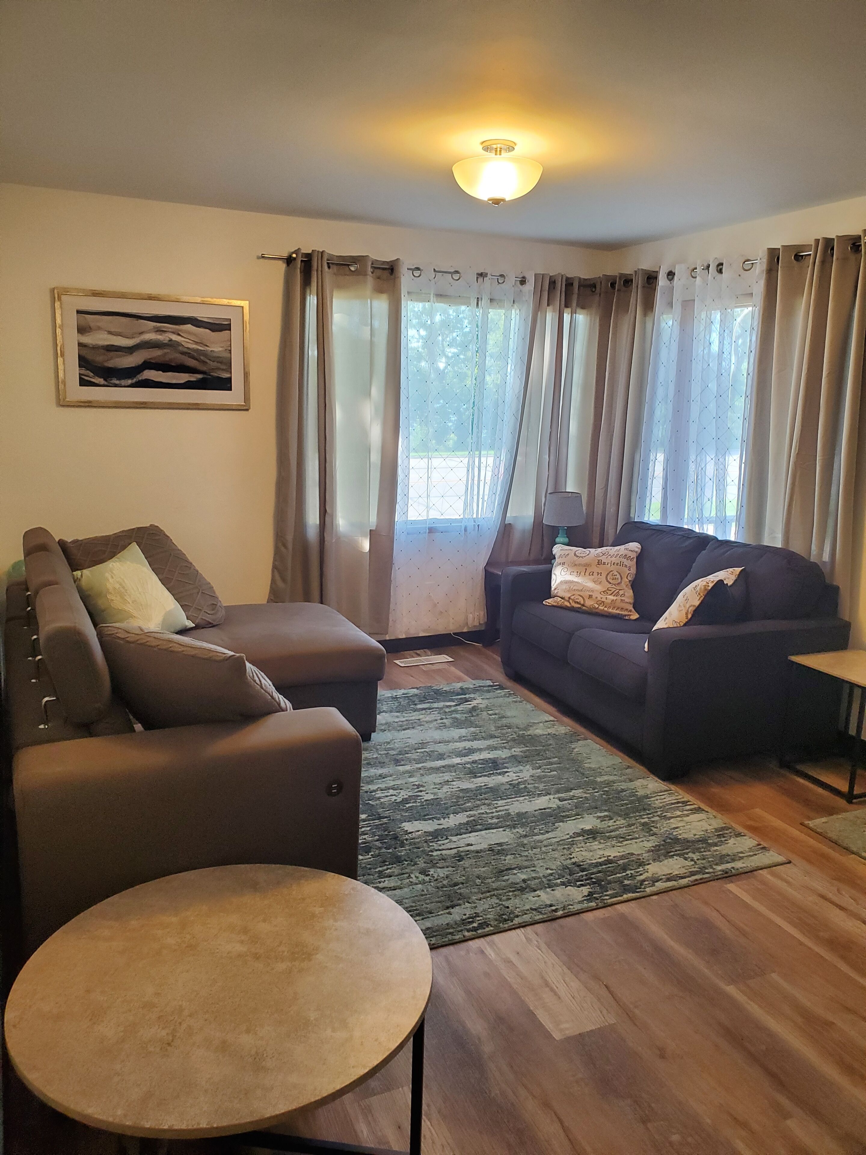 Un salon avec un canapé, un fauteuil et une petite table.