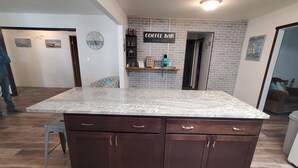 A kitchen with a large island, dark brown cabinets, and a coffee bar sign. - Lake view home on 1.3 acres, lake access 1 block away.
Camper parking available. (Spirit Lake)