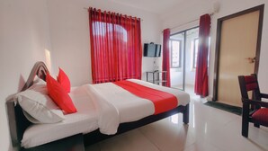 Habitació d'hotel amb un llit, una televisió, una cadira i una porta.