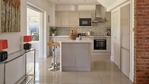 A modern kitchen with a central island, a microwave, and a dishwasher. - Estate Lodge -  Luxury Cottages (Leominster)