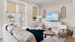 A living room with a sofa, chairs, a coffee table, and a television.