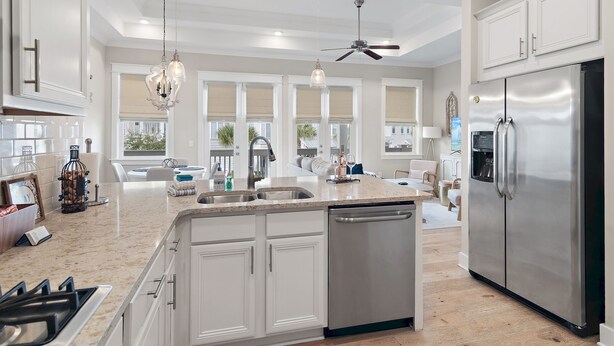 A spacious kitchen with a large island, stainless steel appliances, and pendant lighting.