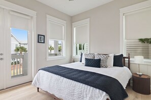 A bedroom with a bed, a nightstand, and a window with blinds.