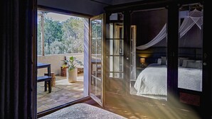 A bedroom with a large bed, a window, and a view of the outdoors.