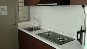 A compact kitchen with two sinks, a stove, and a microwave.