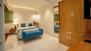 Une chambre à coucher moderne avec un lit, des tables de chevet, une armoire et un miroir.