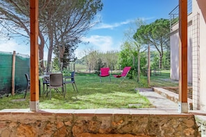 Una zona patio con arredi da esterno, un muro in pietra e vista sul paesaggio circostante.