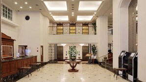 A spacious lobby with a marble floor, a central floral arrangement, and a reception desk with a counter. - KOKO HOTEL Nagoya Sakae (Nagoya)