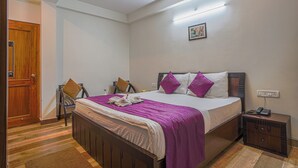 Quarto com cama de madeira, mesa de cabeceira, cadeira e porta.