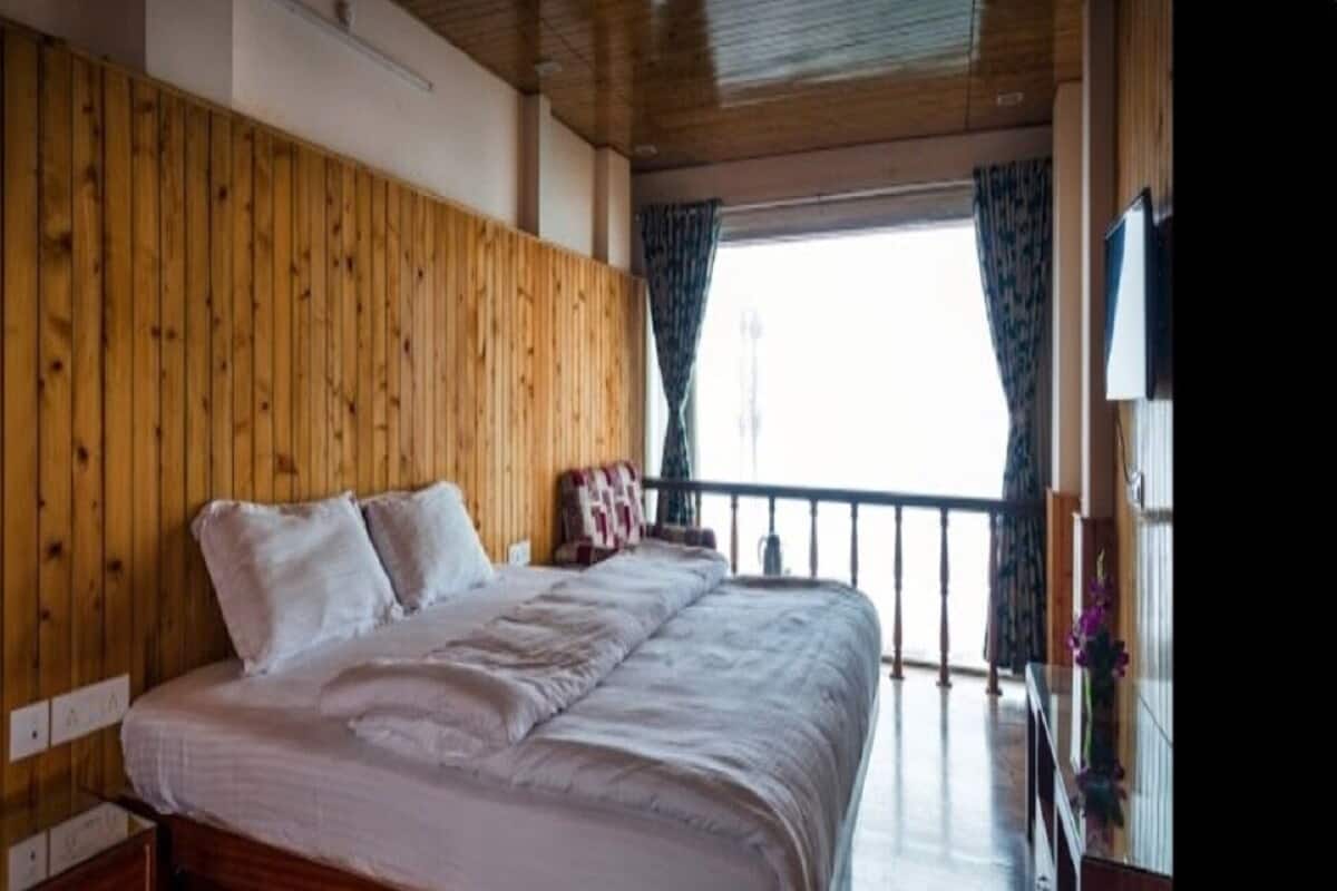 Un dormitorio con paneles de madera, una cama grande, una mesita de noche y un aparador.