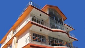 Un hotel de varios pisos con balcones, ventanas amplias y un diseño arquitectónico moderno.
