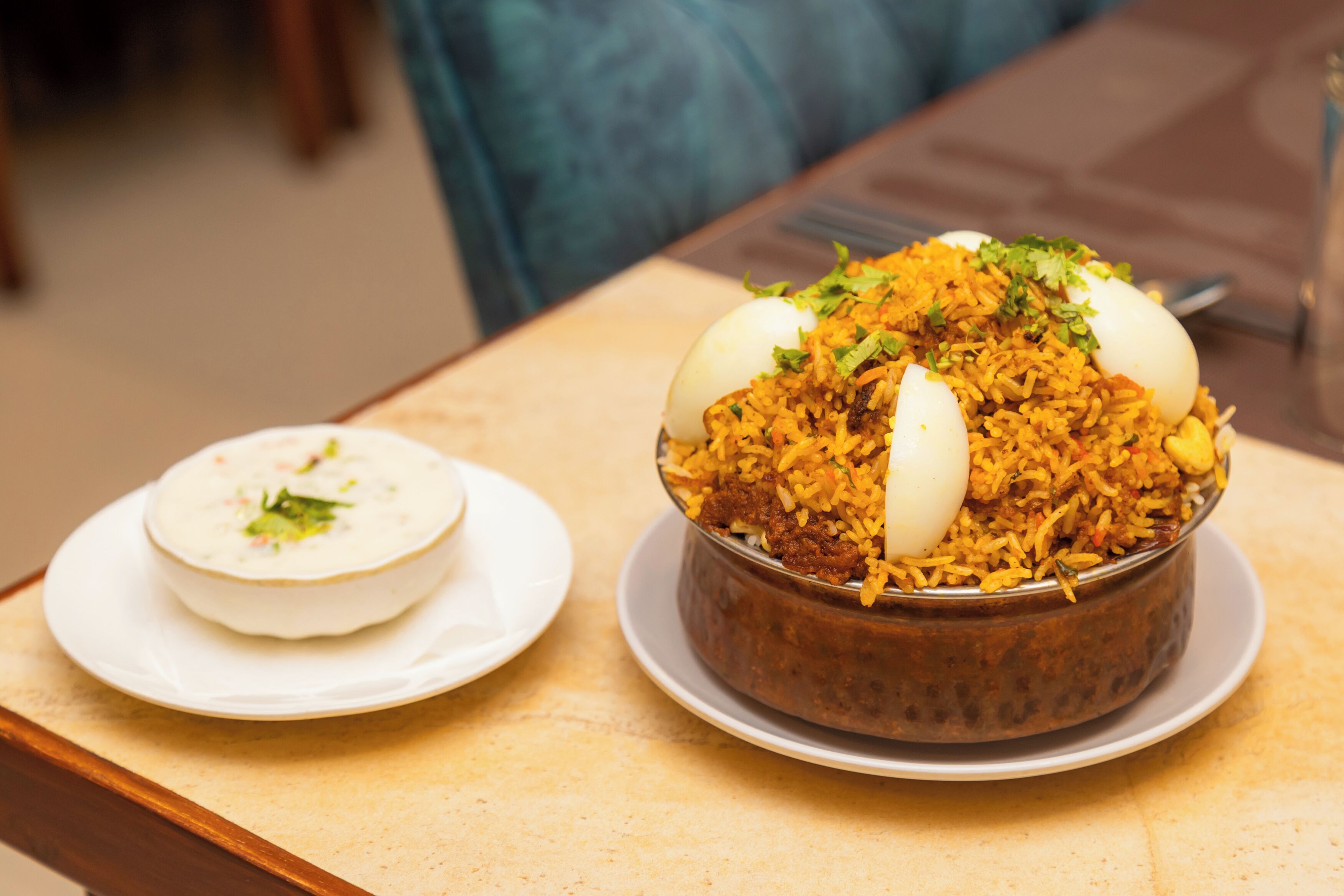 Ett bord med en skål biryani och en tallrik med kokta ägg.