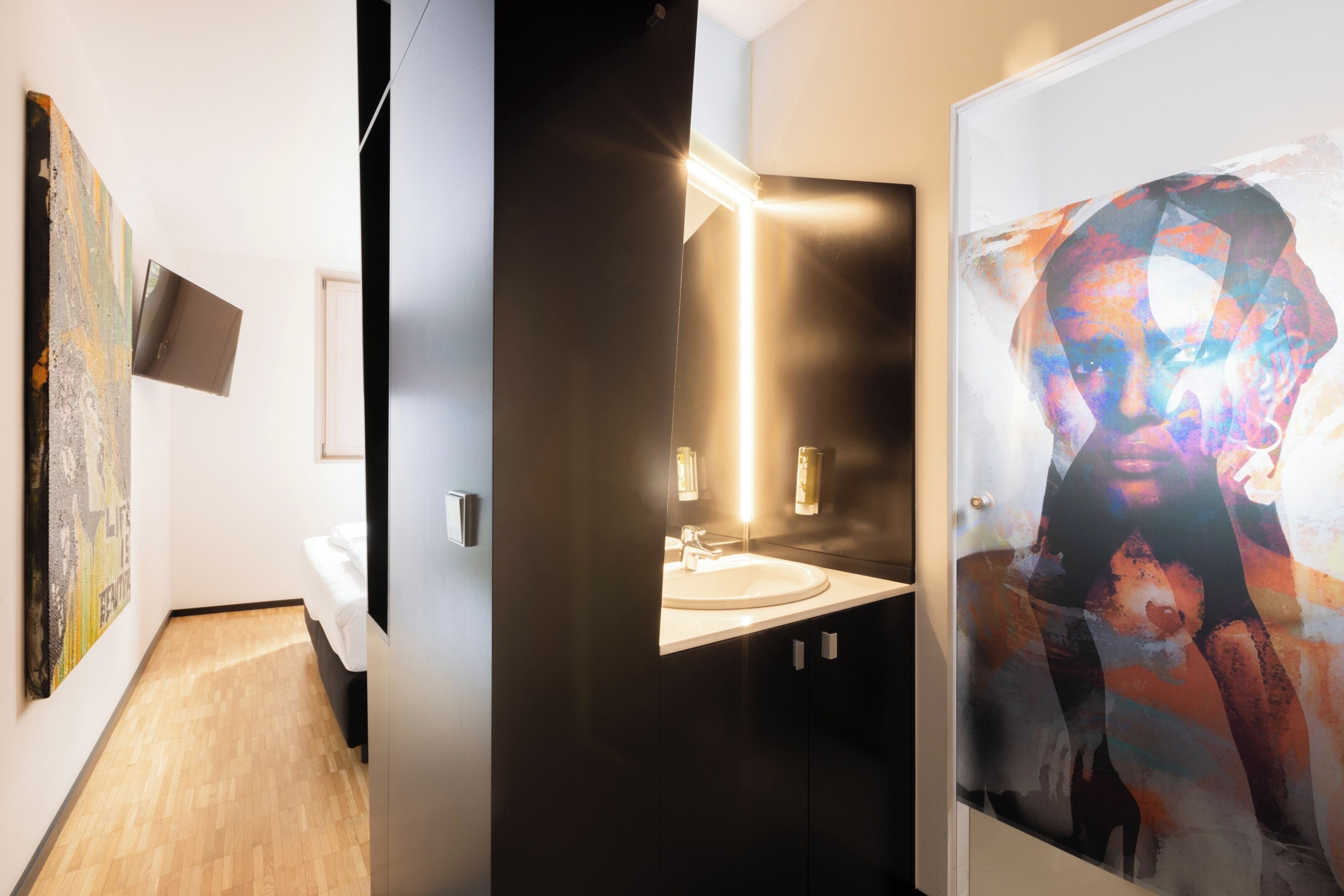 Un baño moderno con un tocador oscuro, un lavabo redondo y un espejo.