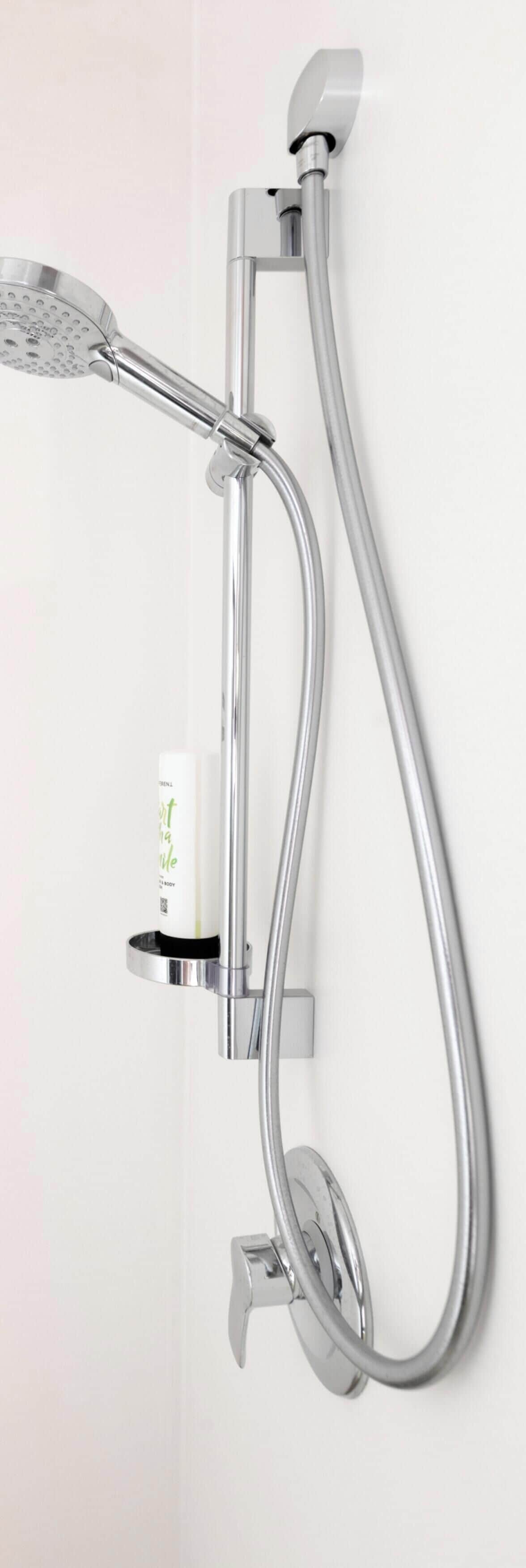 A wall-mounted shower with a handheld showerhead and a flexible hose.