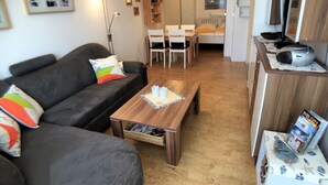 Una sala de estar moderna con sofá, mesa de centro y comedor.