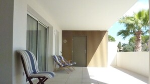 A balcony with two sun loungers and a door.