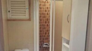 Un baño con inodoro, ducha y lavamanos.