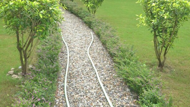 A garden pathway leading to a building with a balcony. - Corbett Comfort Lodge (Ramnagar)