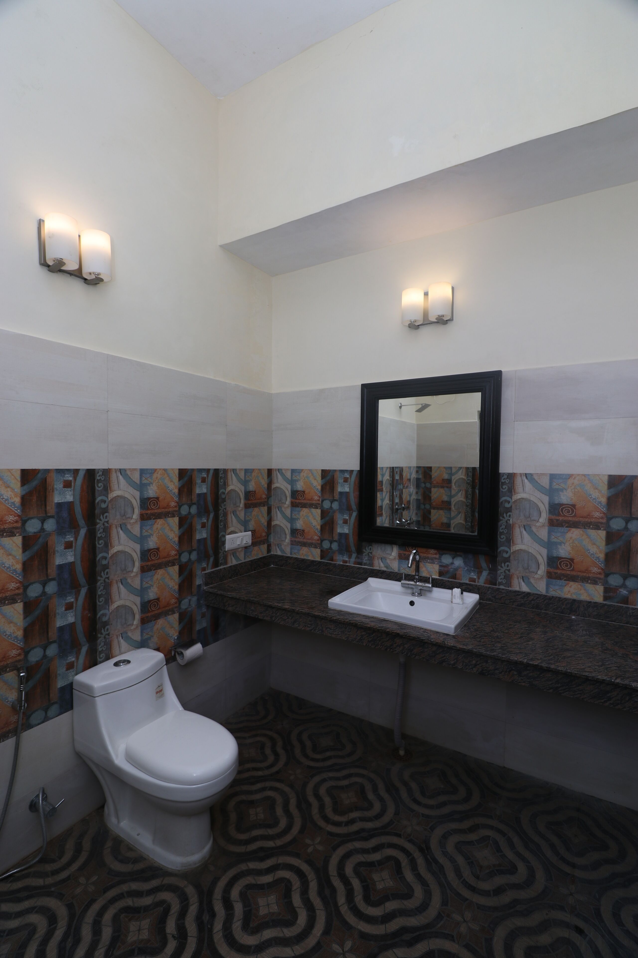 A bathroom with a toilet, sink, and mirror.