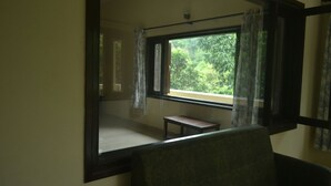 A room with a large window, a bench, and a chair. - Corbett Comfort Lodge (Ramnagar)