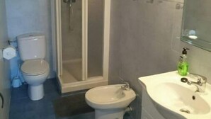 Een badkamer met toilet, bidet en wastafel.