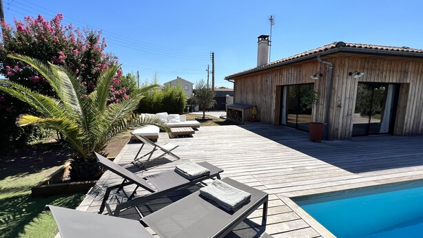 A wooden deck with lounge chairs and a swimming pool. - Large villa with swimming pool on the outskirts of Bordeaux (BRUGES)