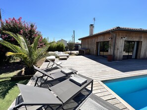 A wooden deck with lounge chairs and a swimming pool. - Large villa with a swimming pool on the outskirts of Bordeaux (BRUGES)