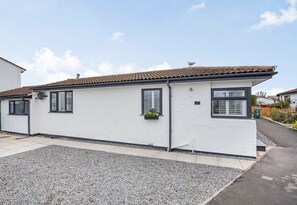 A single-story house with a tiled roof, white exterior walls, and black window frames. - Tegfan Holiday Home, North Wales With Hot Tub (Abergele)