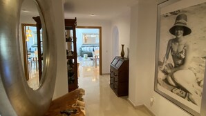 A hallway with a large mirror, a framed artwork, and a wooden console table. - Penthouse Javea 100 meters  from the beach (Xàbia)