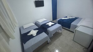 A small, clean room with two beds, a desk, and a blue door. - Mananaue Villa (Ipojuca)