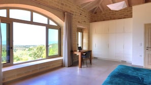 A room with a large window, a desk, a chair, and a wardrobe. - Luxury villa with a fantastic view, the pool can be heated (Rethymnon)