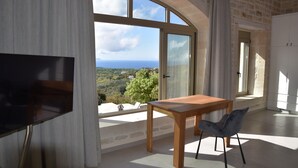 A modern room with a large arched window offering a scenic view of the landscape. - Luxury villa with a fantastic view, the pool can be heated (Rethymnon)