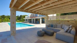 A covered outdoor area with a pool, lounge chairs, and a sofa. - Luxury villa with a fantastic view, the pool can be heated (Rethymnon)