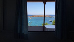 A room with a large window overlooking a coastal view. - Remarkable 3double-bed House in Daskalio (Lavreotiki)