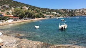 A coastal area with clear waters, boats, and buildings on a hillside. - Remarkable 3double-bed House in Daskalio (Lavreotiki)