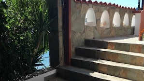 A set of stone steps leading to a covered area with a view of the sea. - Remarkable 3double-bed House in Daskalio (Lavreotiki)