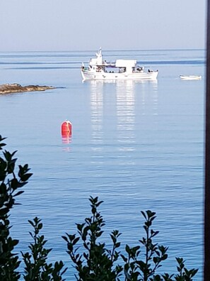 A calm body of water with a large white boat and a smaller red buoy. - Remarkable 3double-bed House in Daskalio (Lavreotiki)