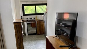 A modern kitchen with a built-in stove, oven, and a wooden countertop.
