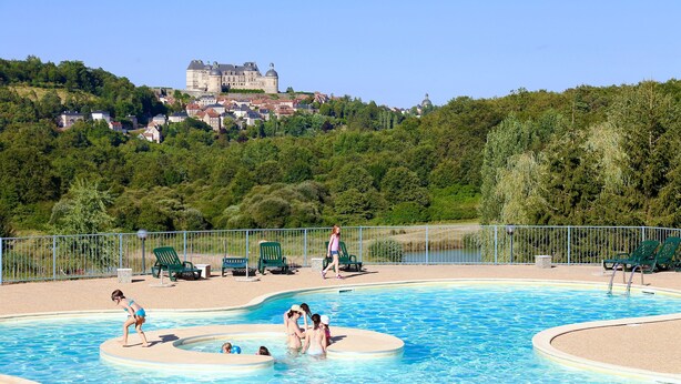 A swimming pool with a castle in the background. - Les SOURCES Premium, SPA, Swimming pool, Fishing pond, Playground, Games room... (Hautefort)