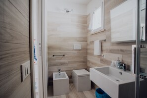 Chuveiro, secador de cabelo, bidê, toalhas de banho