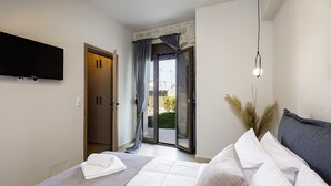 A bedroom with a bed, a television, a sliding glass door, and a wall-mounted light fixture. - Stone project villa, pool,near tavern,supermarket (Pigi)